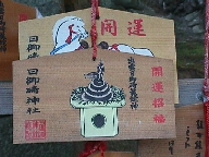 Two emas: a white horse, and two snakes on an offering plate.