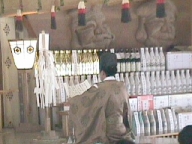 Shinto priest reading an oracle, with images of Ebisu and Daikoku.
